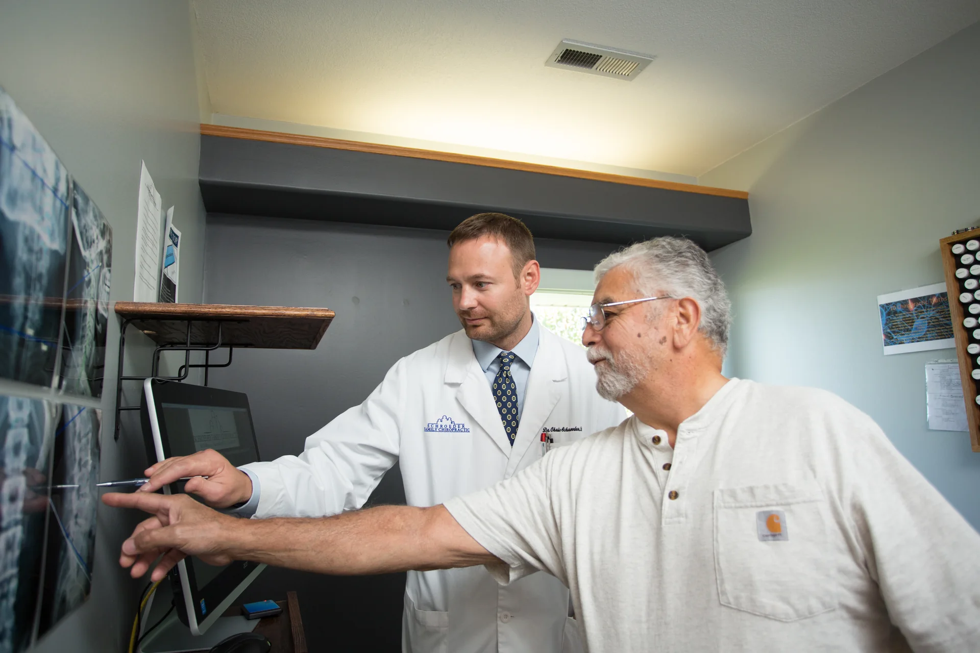 A clinician and patient reviewing back X-rays