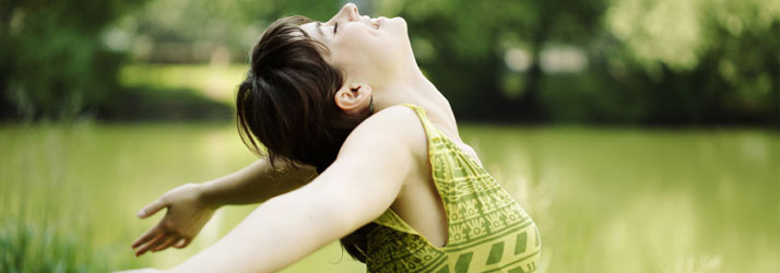 Woman In Green Dress In Field Taking A Deep Breath