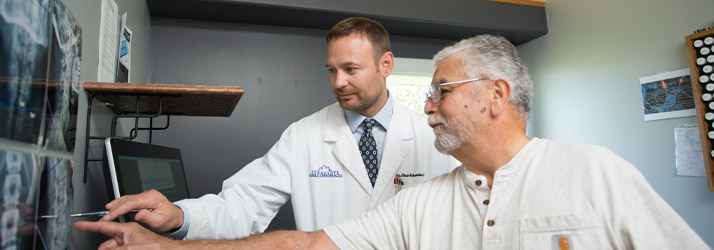 Chiropractor Wichita KS Chris Schroeder Chiropractor Chris Schroeder Pointing To X-Ray With Patient
